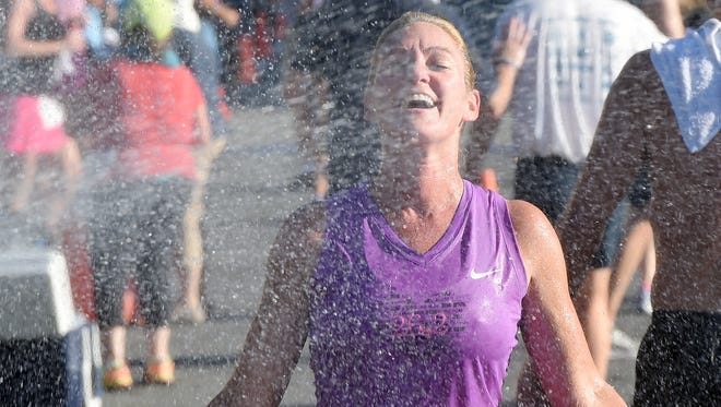 Linda Schwartz-Chi from Rehoboth Beach cools off under hose spray as Over 300 runners and walkers turned out for the 19th Annual Run for J.J. 5K & 5K Walk held on Sunday July 24th in downtown Rehoboth Beach.