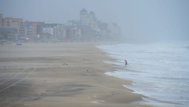 A person runs out of the water where he was attempting to swim in the rough surf during what is being called "Potential Tropical Cyclone 10" in Ocean City, Md. on Tuesday, August 29, 2017.
