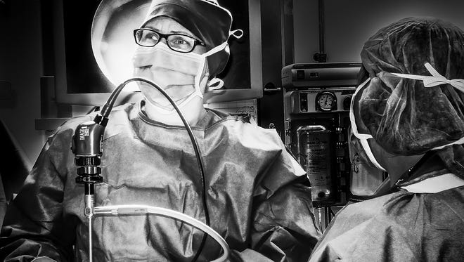 Dr. Thomas Mammen's “Taking a Look,” a photo of a resident looking at an off-camera screen display during a laparoscopic procedure, earned a photojournalism best in show award in the 2018 Wilmington International Exhibition of Photography.