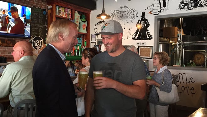 Maryland Comptroller Peter Franchot, left, clinks glasses with RaR Brewing's J.T. Merryweather at the brewery's Cambridge, Maryland location on Tuesday, June 27.