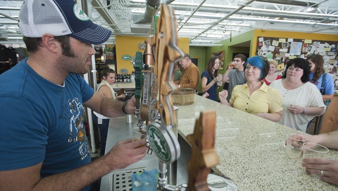Visitors enjoy beer samples in the tasting room at Dogfish Head Craft Brewery in Milton.