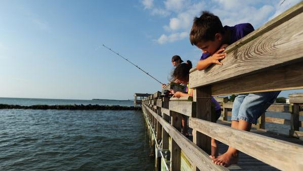 Brayden Dycus, right, keeps a watchful eye on the bobber at the end of his friend Lynnze Ruland’s fishing line while the pair fish off the Cape Charles Pier.