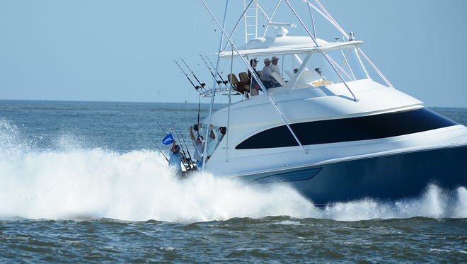 A deep sea fishing boats with the white marlin flag raised comes in from the Atlantic Ocean into the Ocean City Inlet on their way to Harbour Island Marina on Wednesday, August 9, 2017 during the White Marlin Open.