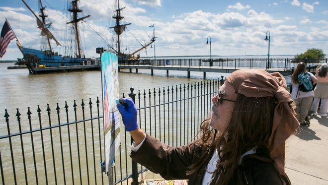 Artist Dennis Young works on his painting at the pier during the ribbon cutting ceremony for the grand opening of the pier in Old New Castle at Battery Park which replaces the one destroyed by Superstorm Sandy back in 2012.