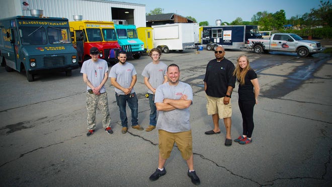 John Berl, owner of Custom Concessions, a food truck-building and repair business, stands with his fellow employees.