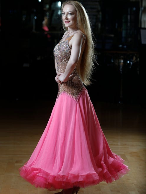 Anna Akarman wears a pink chiffon ballroom dance dress embellished with Swarovski crystals by Donna Hamza and neutral dance pumps.