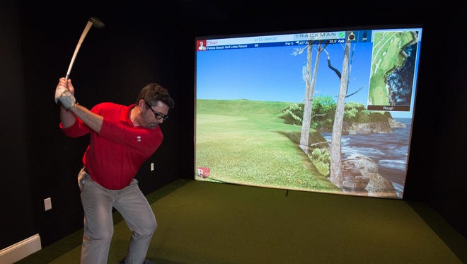 Ethan Jack, a resident at the Peninsula community, plays Pebble Beach golf course virtually in the newly built clubhouse.