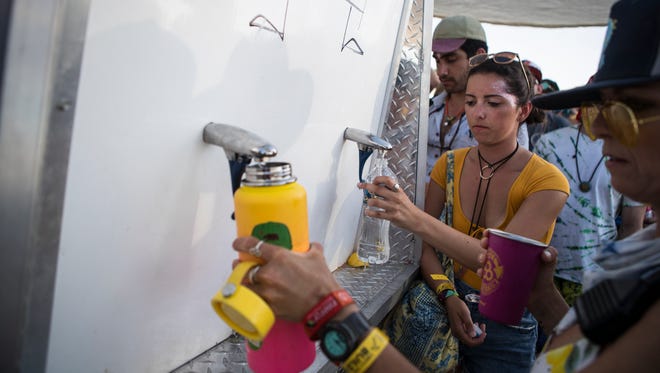 Festival goers refill their water bottles at a refill station during the day 3 of Firefly Music Festival in Dover.