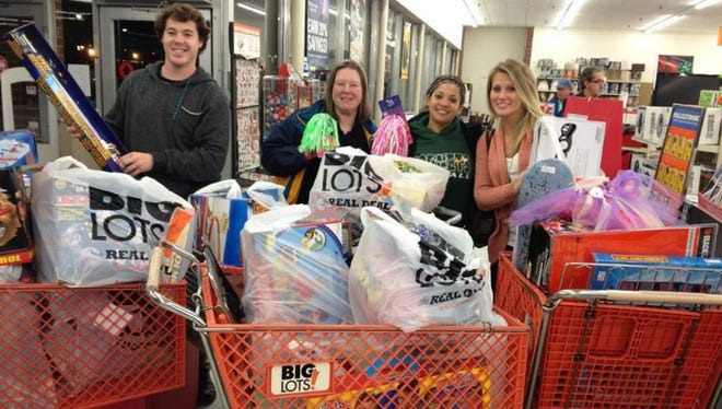 Corlie Budd, far left, shops with fellow Greene Turtle employees for gifts with money earned during the company's annual Tips for Tots initiative.