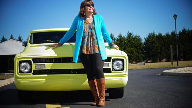 Virginia Griffith wears a turquoise and gold mod tunic and black ponte' pants from Dress Barn; turquoise long sweater by Susan Graver; and brown boots from QVC;