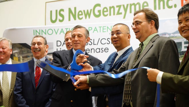 Gov. John Carney and CEO Gaofeng Liu of NewGenzyme cut a ribbon during a ceremony to celebrate the launch of NewGenzyme's new production facility. US NewGenzyme manufactures an all-natural bio-enzyme used to whiten baking flour at the new facility.
