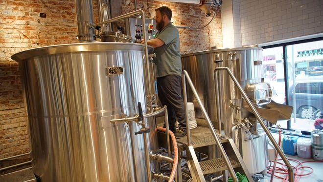Andrew Rutherford, head brewer at Stitch House Brewery, cleans a brewing tank at the new brewery opening soon on N. Market St.