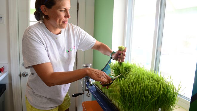 Lisa Daisey-DiFebo makes a fresh wheatgrass shot at her store in Ocean View on Wednesday, June 21, 2017. Juicebox also has a location in Rehoboth Beach as juicing has become popular in beach resorts.