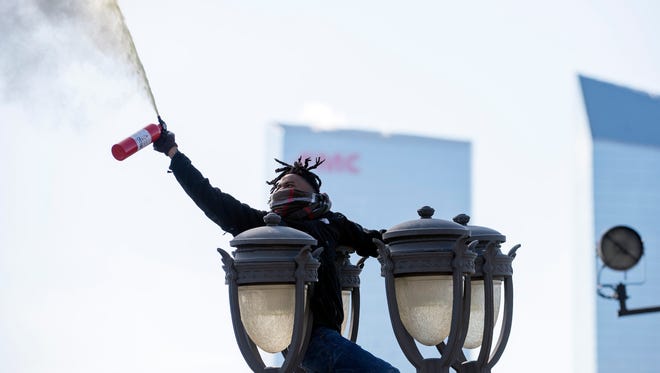 A fan sprays a fire extinguisher atop a light post during the Eagles Super Bowl championship parade outside the Museum of Art.