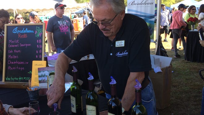 Bordeleau Winery owner and winemaker Tom Shelton pours samples for visitors to his booth. The winery separated their tasting lines into dry reds, dry whites and sweet wines.