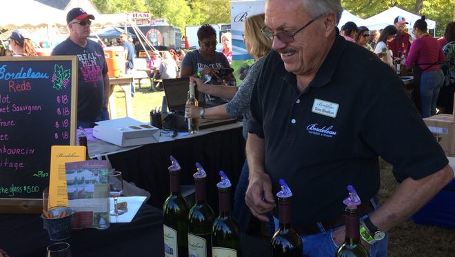 Bordeleau Winery owner and winemaker Tom Shelton pours samples for visitors to his booth. The winery separated their tasting lines into dry reds, dry whites and sweet wines.