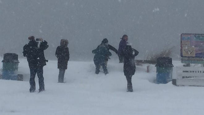 People frolic in the snow at Rehoboth Beach on Saturday.