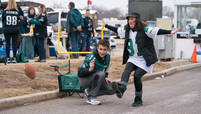 Angela Keegan and her son Jacob, 14, of West Deptford, NJ kicks a field goal as thousands tailgate early Sunday morning for the NFC Championship game at Lincoln Financial Field.