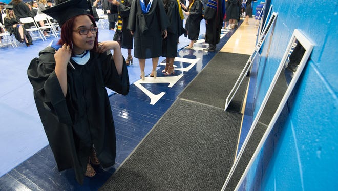 Jazzmine Baker of Troy, N.Y., fixes her hair before the start of the Wesley College Spring Commencement in Dover.  A total of 244 graduated.