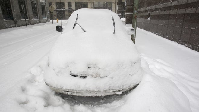 A car rests on Shipley Street under a blanket of snow in Wilmington, Saturday afternoon, Feb. 6, 2010.