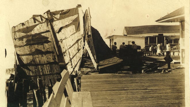 Damage to the Boardwalk is shown with a fishing boat lying against the Boardwalk from the storm of 1933.