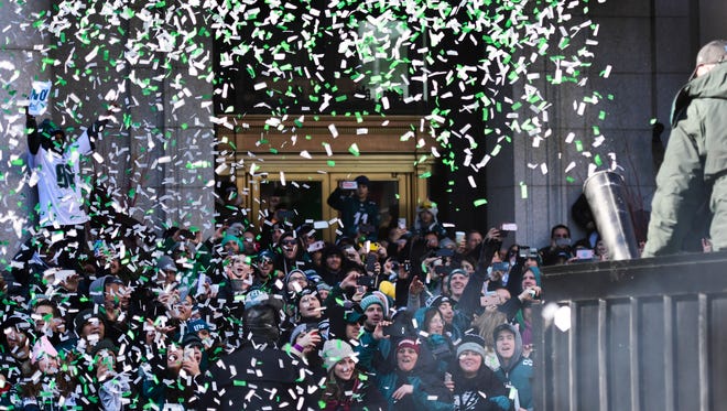 Eagles fans are doused with ticker tape confetti during festivities on February 8, 2018 in Philadelphia, Pennsylvania. The city celebrated the Philadelphia Eagles' Super Bowl LII championship with a victory parade.