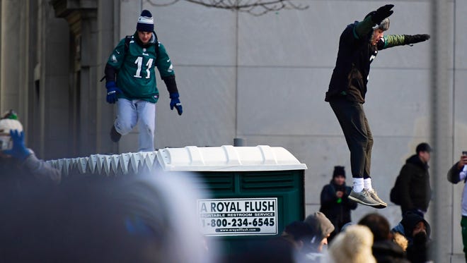 Eagles fans run and jump off of portable urinals during festivities on February 8, 2018 in Philadelphia, Pennsylvania. The city celebrated the Philadelphia Eagles' Super Bowl LII championship with a victory parade.