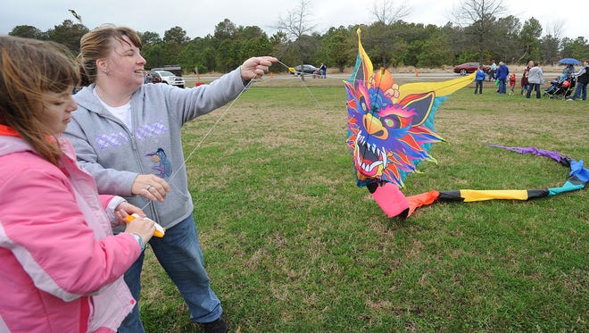 Gena Evans and Alicia Hamilton work to get their kite airborne as Despite cloudy and rainy weather, the 48th Annual Kite Festival was held on Friday March 25th at Cape Henlopen State Park near Lewes with a good crowd on hand flying all kinds of kites and creations.