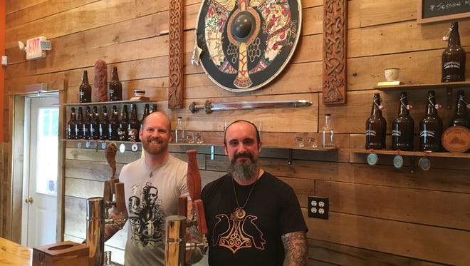 The Brimming Horn Meadery owners J.R. Walker, left, and Jon Talkington behind the bar. The two built the inside of their mead hall by hand.