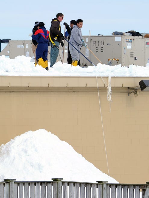 Workers clearing snow from the roof of WalMart in Milford Tuesday Feb. 9, 2010.  Unconfirmed report the store closed yesterday due to a portion of roof that collapsed under the weight of snow.