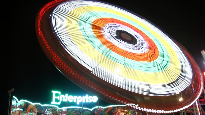 Photographer Dennis Norwood captures the light streaks of the Enterprise, a ride at the Delaware State Fair.