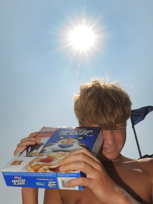 Collin Thompson, of Rehoboth Beach, tried the cereal box method as many watched the  solar eclipse on the boardwalk at Rehoboth Beach on Monday, Aug. 21.