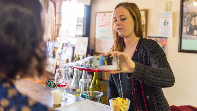 Jessica Rosenberg of Nassau Valley Vineyards pours a tasting portion for a customer.