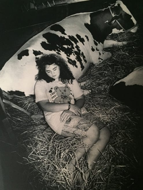 1988: Martha Phipps, of Centerville, naps with one of her Holstein cows. See more vintage images of the Delaware State Fair.