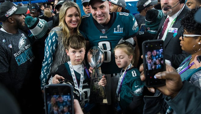 Eagles punter Donnie Jones has his photo taken with his family and the Vince Lombardi Trophy Sunday at US Bank Stadium.