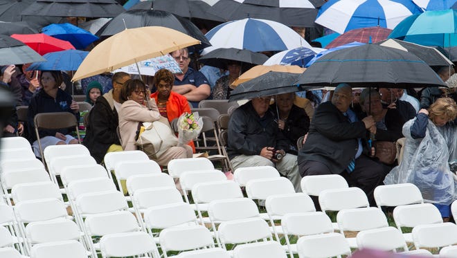 Family wait in the rain before the start of the Wesley College Spring Commencement in Dover.  A total of 244 graduated.