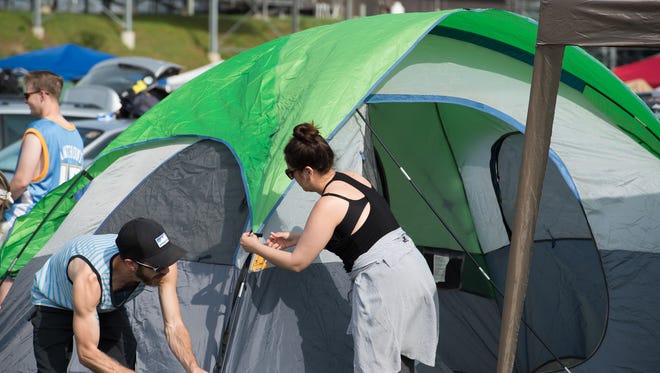 Andrea Aveiga of Allentown, Pa., sets up her tent in the camping area at the Firefly Music Festival in Dover.