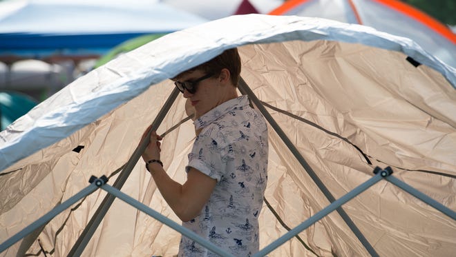 Zac Pantle of Wilmington sets up a tent in the camping area at the Firefly Music Festival in Dover.
