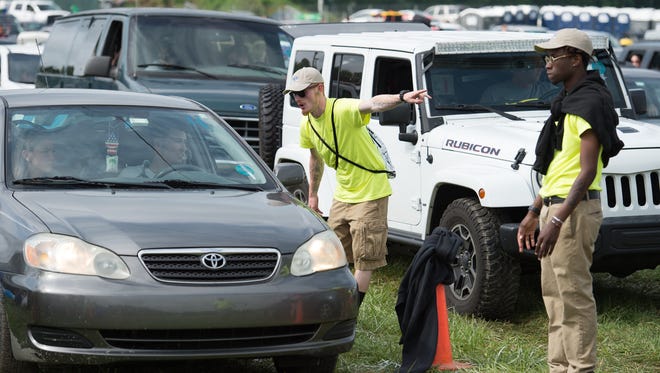 Security directs vehicles to be search upon arrival to the Firefly Music Festival in Dover.
