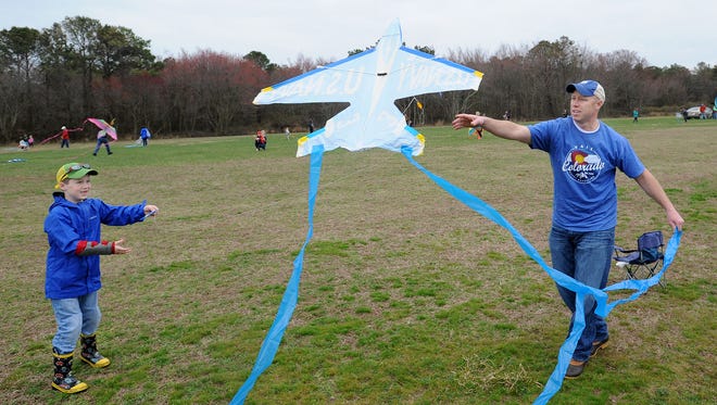Todd Lawson from Harbeson, helps his son Cooper, 7 get their kite to fly, Despite cloudy and rainy weather, the 48th Annual Kite Festival was held on Friday March 25th at Cape Henlopen State Park near Lewes with a good crowd on hand flying all kinds of kites and creations.