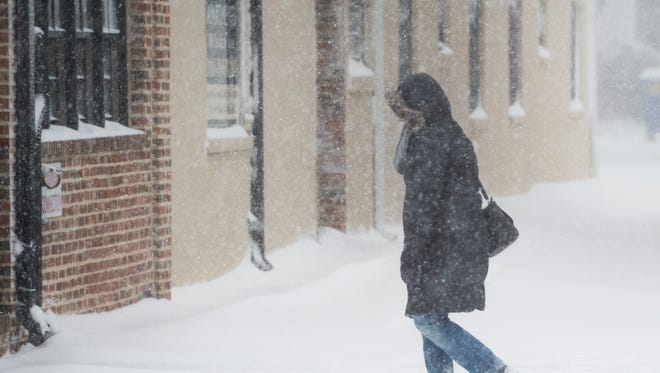 A women walks along Savannah Road as winter storm Helena hits downtown Lewes.