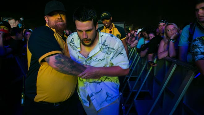 A fan gets escorted out before Logic performs Friday night at the Backyard Stage at the 2018 Firefly Music Festival at The Woodlands in Dover.