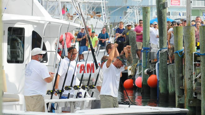 The crew of Two Timing Connie out of Edge Water, Md. celebrate after catching a leading 79lb Wahoo on Tuesday on Day 2 of the 43rd Annual White Marlin Open in Ocean City, Md.