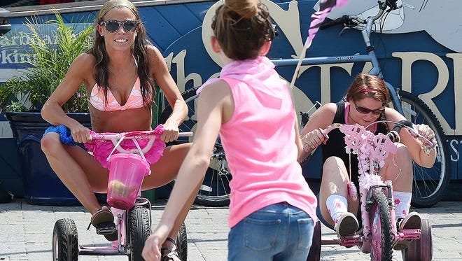 Bethany Slawick from Clayton (left) and Lisa Carey from Lewes compete in the Dewey Beach Annual Big Wheels for Breast Cancer Awareness Races. The event was held at the Starboard on Saturday, Aug. 6. Competitors rode Big Wheel bikes and used Hula Hoops, Dizzy Bats, and bouncy balls in a race to the finish. Several teams raised money for breast cancer research in 95 degree heat.