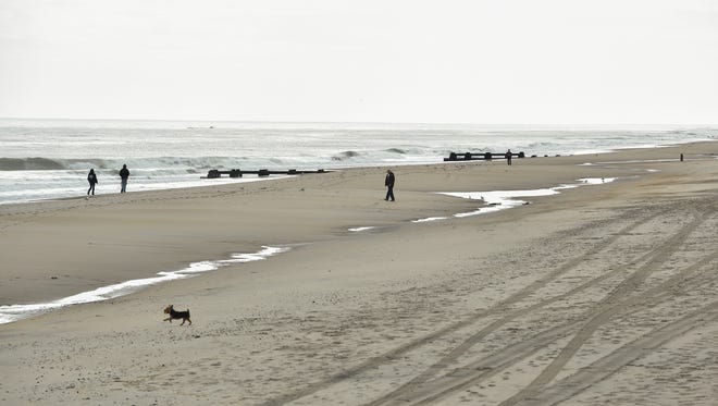 Visitors walk on the sand at Rehoboth Beach