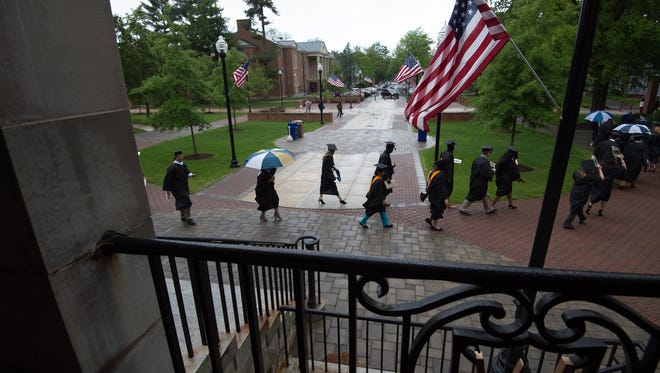 Graduates process in the rain before the start of the Wesley College Spring Commencement in Dover.  A total of 244 graduated.