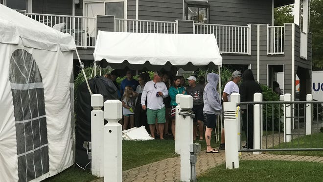 Spectators take shelter from the rain during the first day of The White Marlin Open at Harbour Island Marina in Ocean City, Md. on Monday, August 7, 2017.