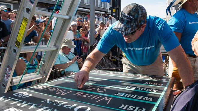 A White Marlin Open staff member writes info for the first place fish brought in by the crew of the Wire Nut of Ocean City on Friday, Aug. 11, 2017. The 95.5 pound marlin is the third largest in the tournament's history.