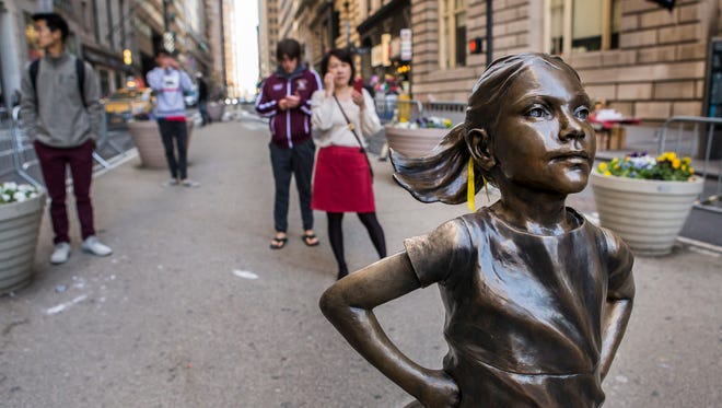 The "Fearless Girl" statue stands facing the "Charging Bull" statue in New York City on Sunday morning, April 23, 2017.