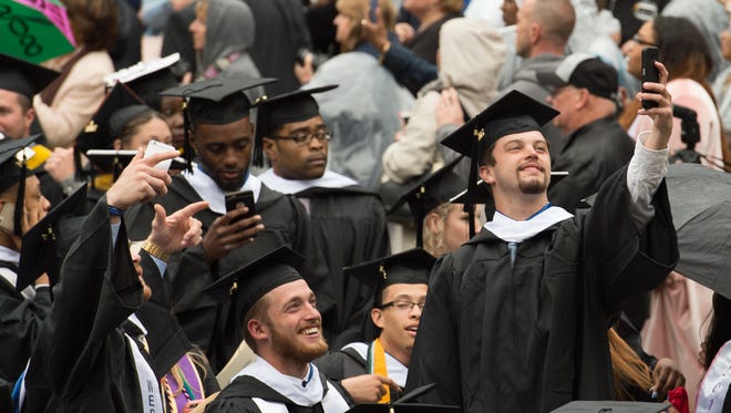 Patrick Barrow takes a group photo with his phone before the start of the Wesley College Spring Commencement in Dover.  A total of 244 graduated.